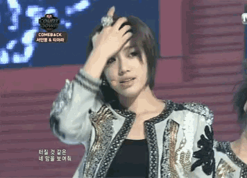 a woman holds her hand to her forehead in front of a screen that says comeback