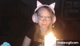 a woman wearing cat ears and glasses is looking at the camera .