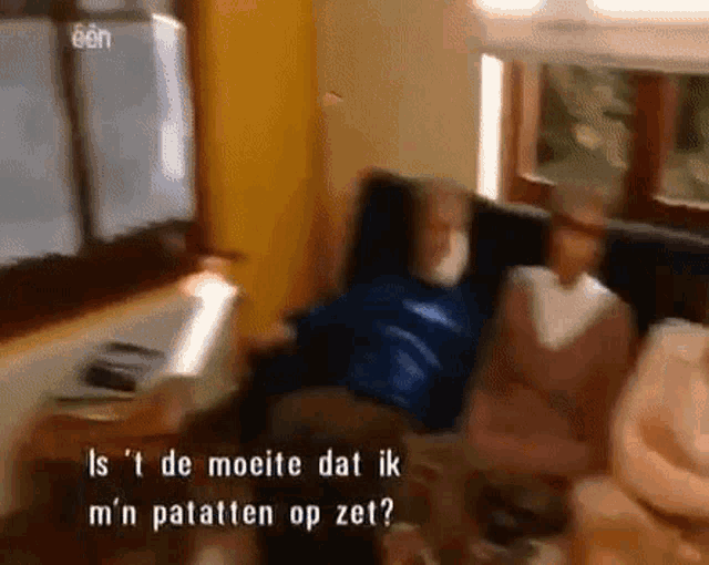 a group of people are sitting on a couch and one of them is talking in a foreign language ..