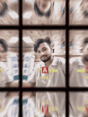 a blurry picture of a man in a white shirt with the letter a on it