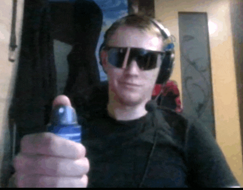 a man wearing sunglasses and headphones holds a spray bottle in his hand