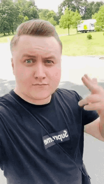 a man wearing a black shirt that says s.m.r.r.q.2