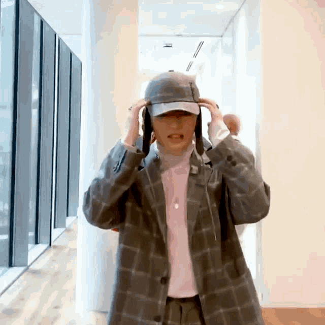 a man wearing a hat and a plaid jacket