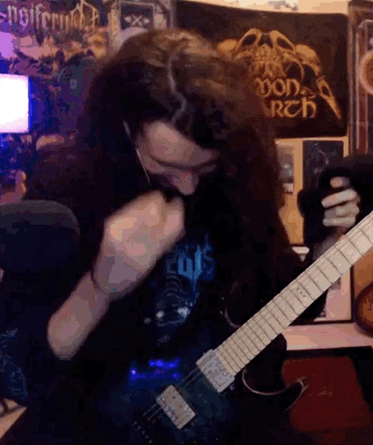 a man with long hair is playing a guitar in front of a poster that says ' doom ' on it