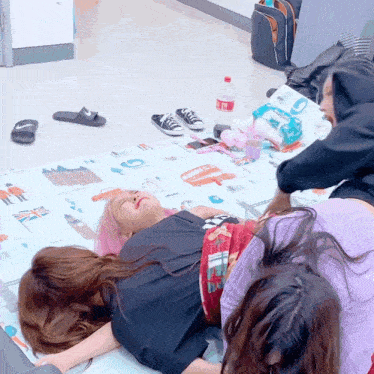 a bottle of coca cola sits on the floor next to a woman laying on a mat