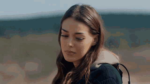 a woman with a backpack looks down at something