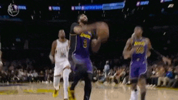 a group of basketball players are playing a game .