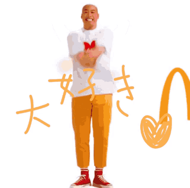 a man wearing a white shirt with a red heart on it makes a heart shape with his hands