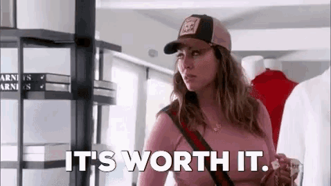 a woman wearing a baseball cap and a pink shirt is standing in a store .