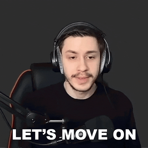 a man wearing headphones is sitting in front of a microphone and says let 's move on