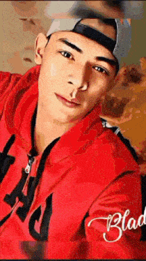 a young man wearing a red hoodie and a baseball cap has the word glad on the bottom right