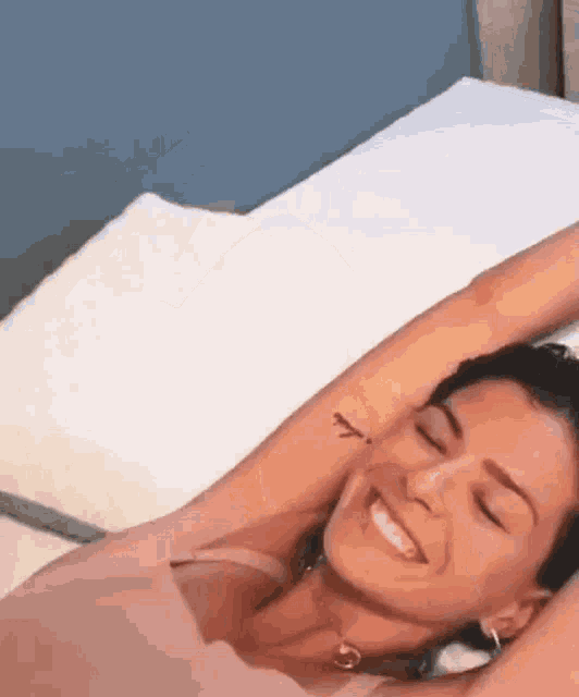 a woman with a tattoo on her arm is laying on a bed .