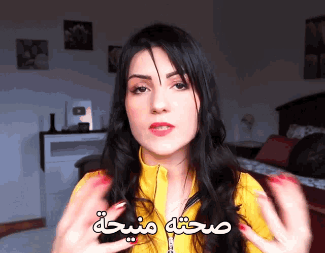a woman wearing a yellow jacket with arabic writing