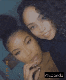 a couple of women are posing for a picture and one of them has a bun on her head