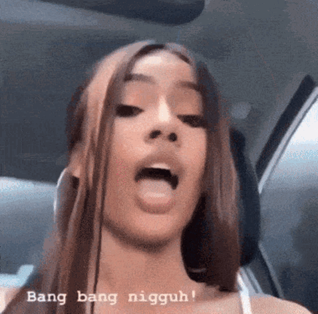 a woman is sticking her tongue out while sitting in a car with the words bang bang nigguh above her