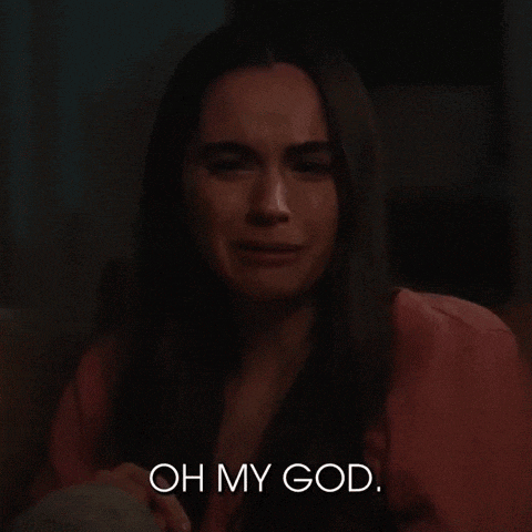 a woman is crying in a dark room and the words oh my god are above her .