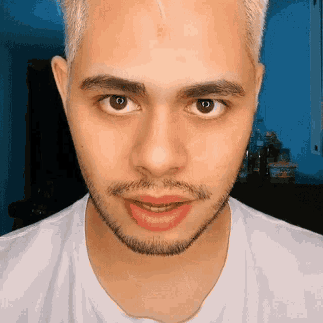 a close up of a man 's face with a beard and a white shirt