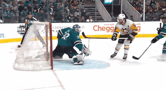 a hockey game is being played in front of a chegg advertisement