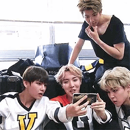 a group of young men are taking a selfie with their cell phones .