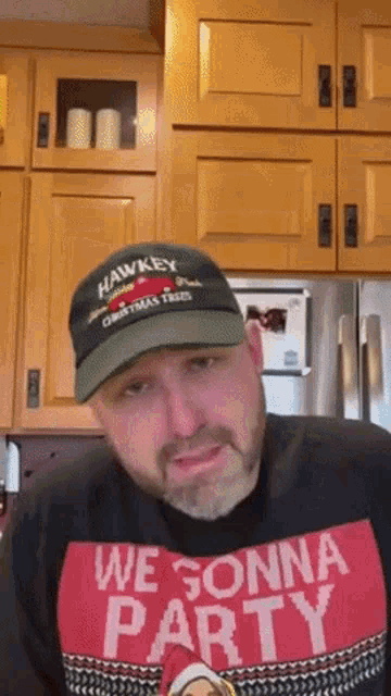 a man wearing a hawkeye hat and a we gonna party shirt