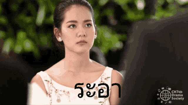 a woman in a white dress stands in front of a sign that says ch7th drama society