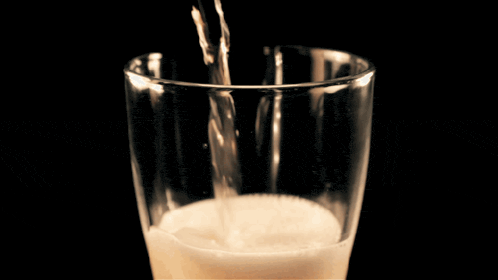a close up of a glass of beer with foam on top