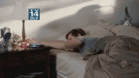 a man is sleeping in a bed with a tv 14 dlv sign above it