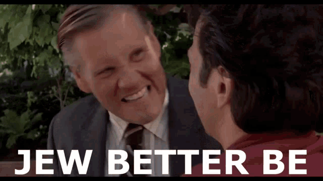 a man in a suit and tie talks to another man with the words jew better be below them