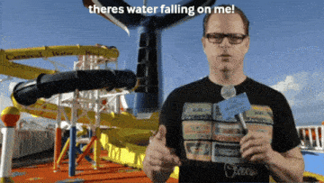 a man is holding a microphone in front of a water slide and says there 's water falling on me
