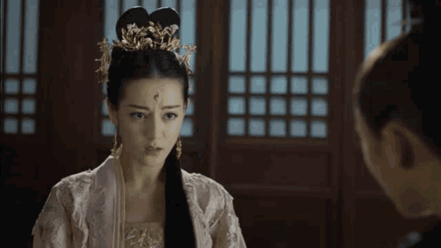 a woman with a crown on her head is standing next to another woman