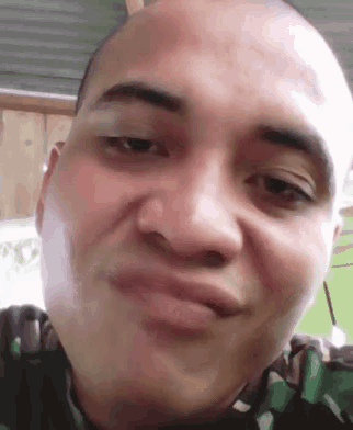 a man with a bald head is making a funny face