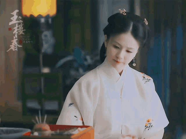 a woman in a white kimono with chinese writing on the front