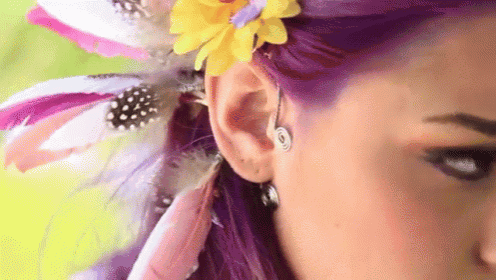 a close up of a woman 's ear with a flower in it