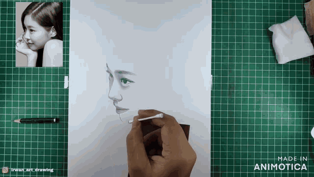 a person is drawing a woman 's face on a piece of paper