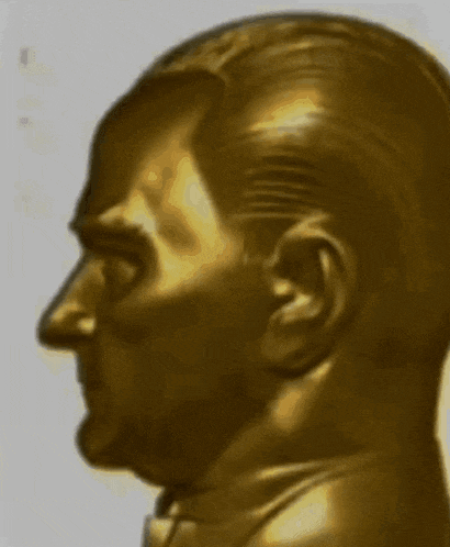 a close up of a golden statue of a man 's face