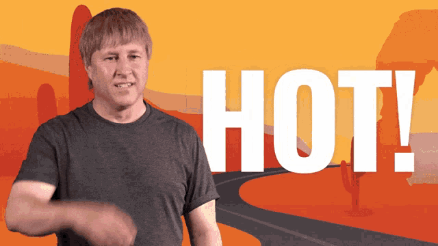 a man in a gray shirt stands in front of a sign that says hot