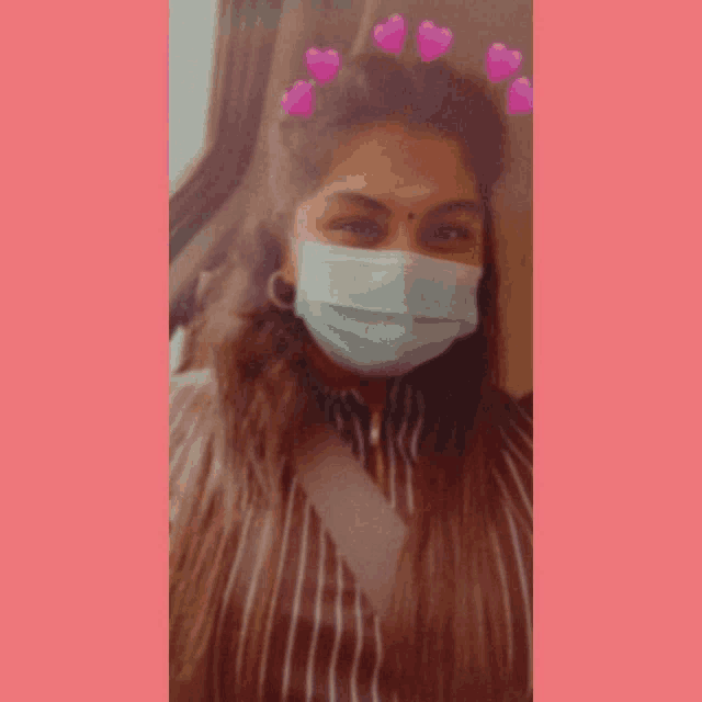 a woman wearing a face mask with hearts on her head