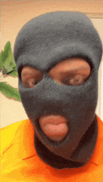 a man wearing a ski mask with his tongue out