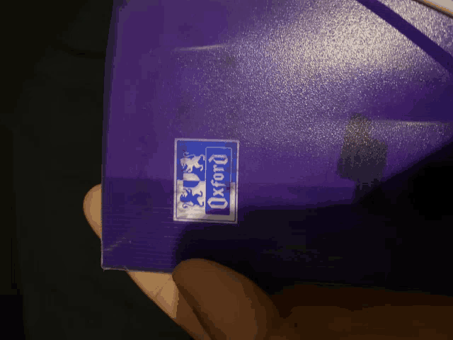 a person is holding a purple box that says oxford