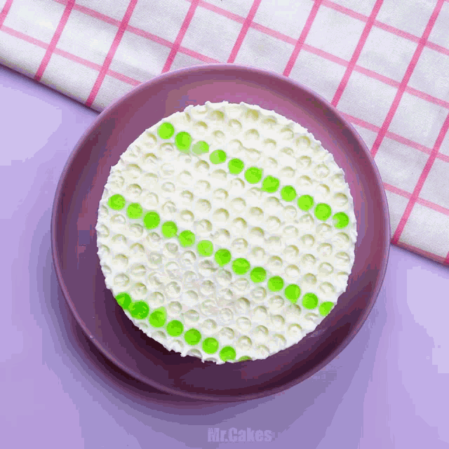 a purple plate with a cake on it and the words mr.cakes on the bottom
