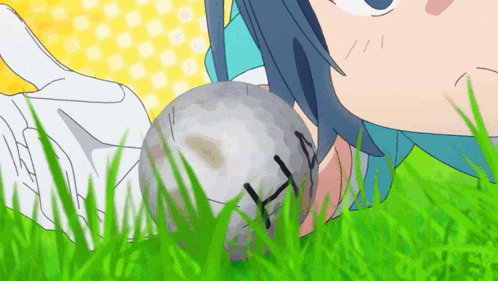 a person laying in the grass with a golf ball