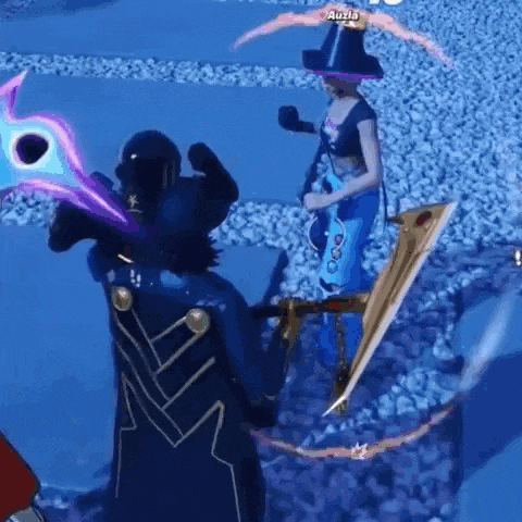 a woman in a witch costume is standing next to a man in a cape .
