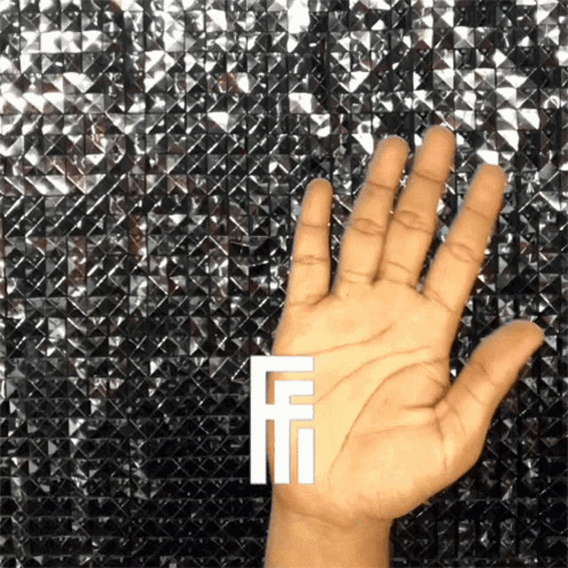 a hand is reaching out in front of a black and silver background with the letter f on it