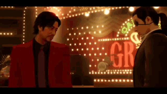 two men are standing in front of a sign that says gr