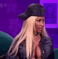 a woman wearing a baseball cap and a leather jacket is sitting in a chair .