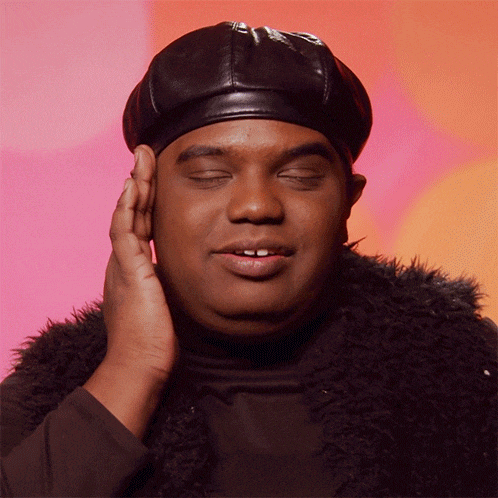 a man with his eyes closed wearing a black hat and fur vest