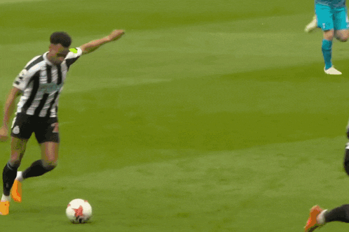 a soccer player kicks the ball in front of a banner that says castore