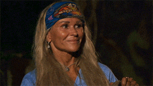 a woman wearing a blue shirt and a headband with the word survivor on it smiles