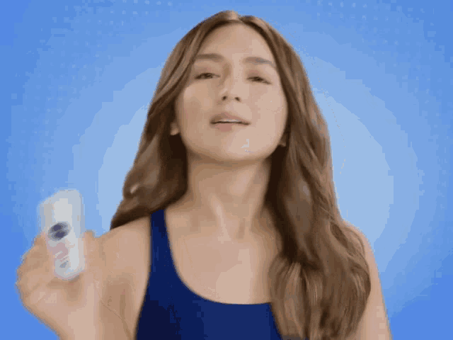 a woman in a blue tank top is holding a nivea roll on