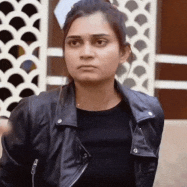 a woman wearing a leather jacket and a black shirt